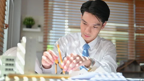 Civil engineer man using compass to measuring scale on a blueprint, working Stock Footage 251559512