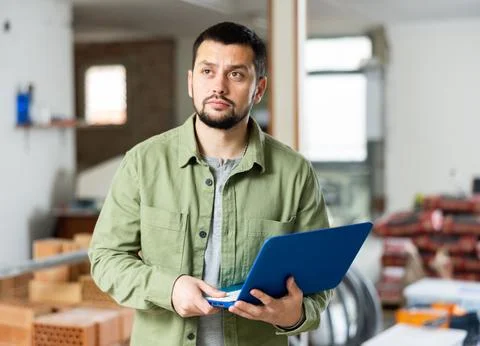 Civil engineer monitors the process of capital repairs on a laptop 스톡 사진