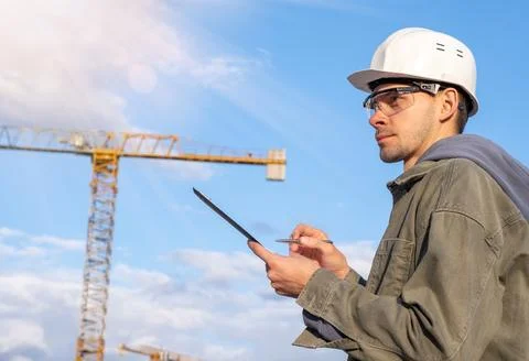 Civil engineer or architect on construction site checking schedule with tab.. Stock Photos
