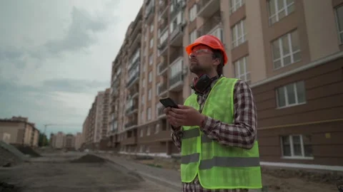 Civil engineer standing on urban construction site of tall apartment buildings Video stock 323879995