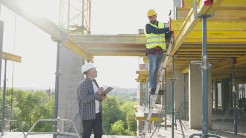Civil engineer supervising worker on construction site scaffolding Stock Footage 343449399