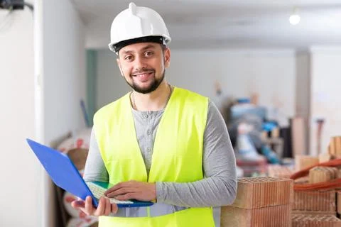 Civil engineer working on a construction site indoors monitors the process of Stock Photos