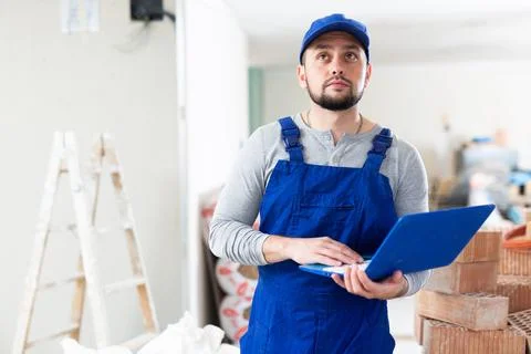 Civil engineer working on a construction site indoors monitors the process of Stock Photos