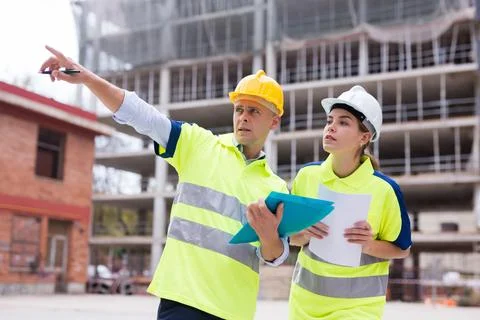 Civil engineers checking work process in construction site Stock Photos