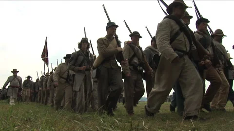 Civil War Confederate soldiers marching onto reenactment Battlefield Stock Footage