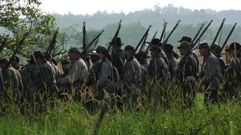Civil War Confederate soldiers marching onto re-enactment Battlefield Stock Footage