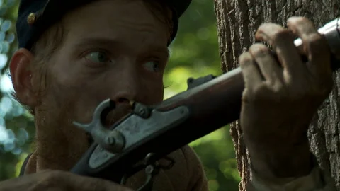 Civil War Union soldier loading and live firing musekt with gunfire and smoke. Stock Footage 148419300