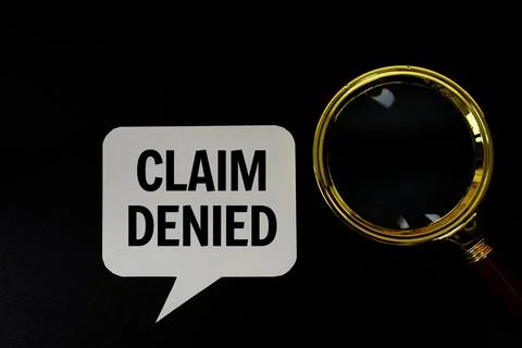 Claim Denied text on speech bluble with magnifying glass top view on black .. Stock Photos