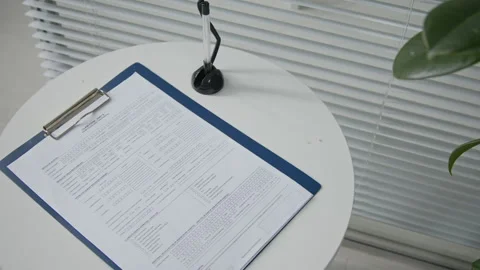 Claim Form with Empty Lines Resting on Table in Waiting Area of Clinic Stock Footage 333197540