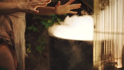 Clairvoyant in dark forest, white smoke from magical boiling cauldron Stock Footage 112743713