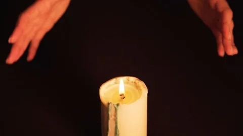 A clairvoyant witch prediction over a candle. Women's hands over the flame are Видео 124978981