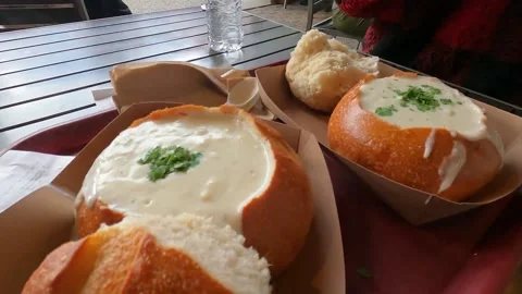 Clam chowder bread bowl dinner table Stock Footage 195283519