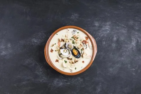 Clam chowder in a brown plate. The main ingredients are shellfish, broth, b.. Stock Photos