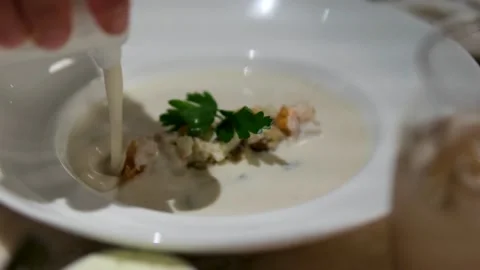 Clam chowder soup served table side from spouted container dramatic presentation Stock Footage 318582512