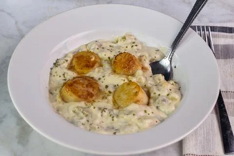 Clam chowder top  with herbs and scallops Stock Photos