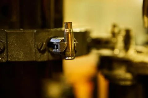 Clamp with brass bullet casing at ammo production plant Stock Photos