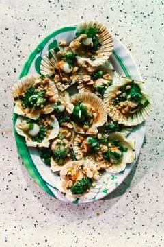 Clams in shells flavored with nuts and spices on a platter Stock Photos
