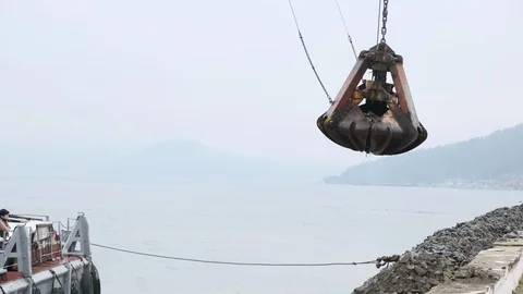 A clamshell crane on a floating platform works Stock Footage 114307607
