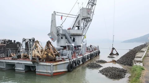 A clamshell crane on a floating platform works Stock Footage 114308047