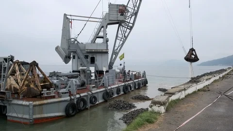 A clamshell crane on a floating platform works Stock Footage 114308055