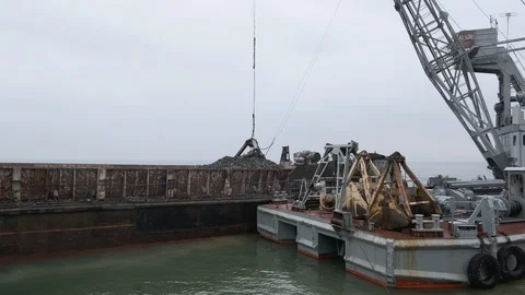 A clamshell crane on a floating platform works Stock Footage 114308487
