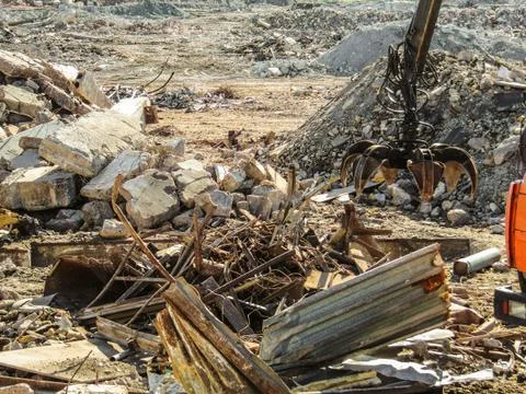 Clamshell grab for cleaning construction garbage and destroyed structures Stock Photos