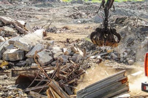 Clamshell grab for cleaning construction garbage and destroyed structures Stock Photos