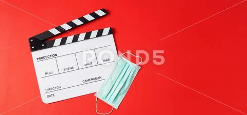 Clapper board and face mask on red background.It is use in video production o Stock-Fotos