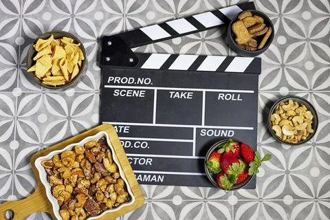 Clapperboard On Film Set Table With nuts, almonds cashews pecans and walnuts coa Stock Photos