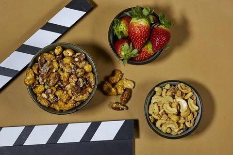 Clapperboard On Film Set Table With nuts, almonds cashews pecans and walnuts coa Stock Photos