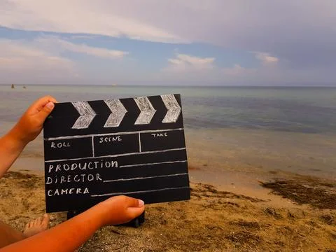 A clapperboard for filmer production in the hands of a man against the backgr Stock Photos