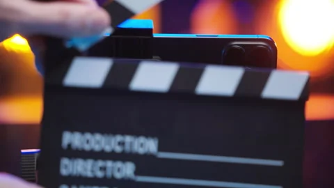 Clapping clapperboard in front of iPhone 15 Pro Max on tripod 4K Stock Footage 260064507