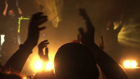 Clapping hands during a concert with yellow back lights Video stock 71812416