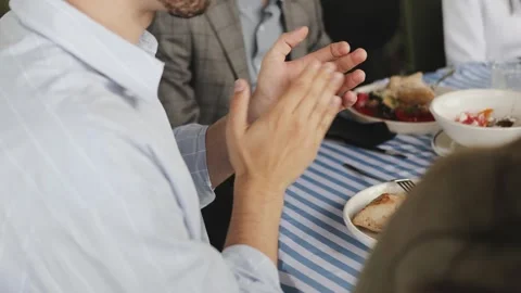 Clapping Hands at a Gathered Meal, Signifying Unity and Celebration in a Social Stock Footage 318063981
