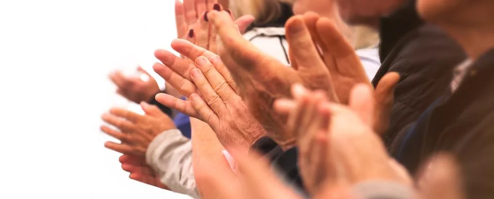 Clapping hands of a group of people in a row on white background Фото