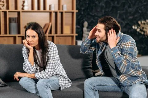 Clarification of relations between spouses. Caucasian couple sitting on sofa in Stock-Fotos