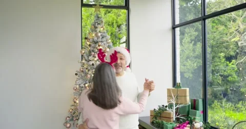 Clasping hands and dancing senior couple spinning dipping and laughing at home Stock Footage 340964262