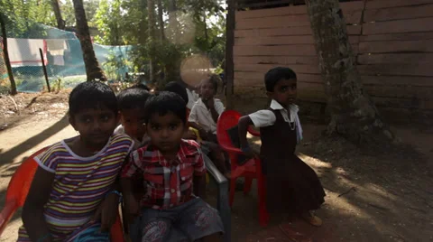 Class of children sit around camera in rural village school in Kerela, India Stock Footage 33660831