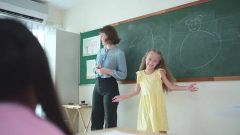 In class, The teacher and students sing together, and the girl dance happily Stock Footage 283055187