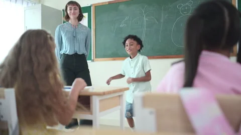In class, The teacher and students sing together, and the boys dance happily Stock Footage 283056845