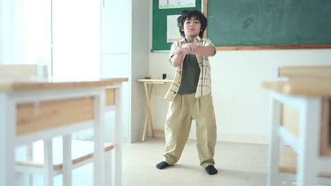 In class, The teacher and students sing together, and the boys dance happily Stock Footage 283059697