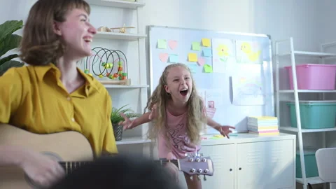 In class, The teacher and students sing together, and the boys dance happily Stock Footage 285325414