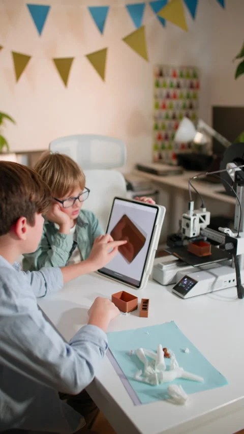 In class two boys at table with a working 3D printer, observing and operating it Stock Footage 335394938