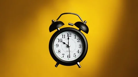 Classic alarm clock on yellow background. Old fashioned alarm clock with bells Vidéo 328016242