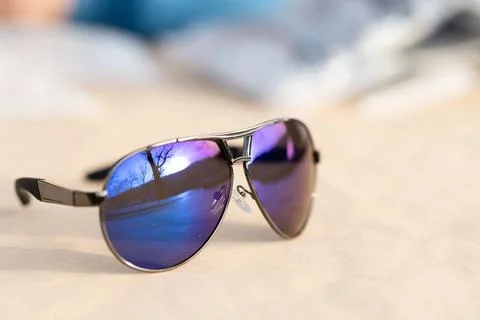 Classic aviator sunglasses model with big blue lenses shoot outside in a sunny Stock Photos