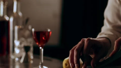 Classic bartender cutting a thin slice of a lemon peel and garnishing a negroni Stock Footage 199458790