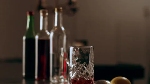 Classic bartender placing cubes of ice into a tall glass in interior classy bar Video stock 199455696