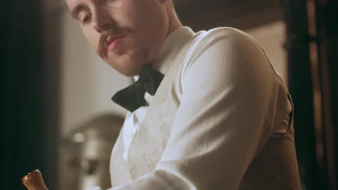 Classic bartender putting bitters in a glass and crushing it with a wooden pistl Stock Footage 199457413