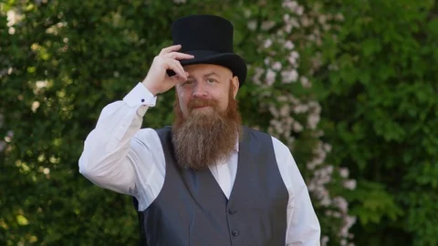 Classic beard gentleman with top hat nicely welcomes the viewer. Stockbeeldmateriaal 107974577
