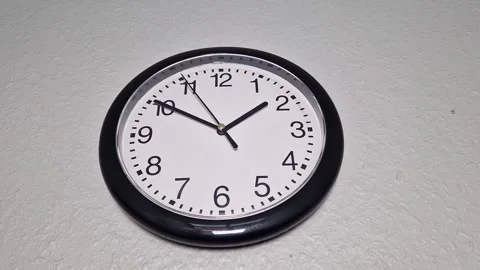 Classic Black Wall Clock on a White Wall 库存影片 344285347